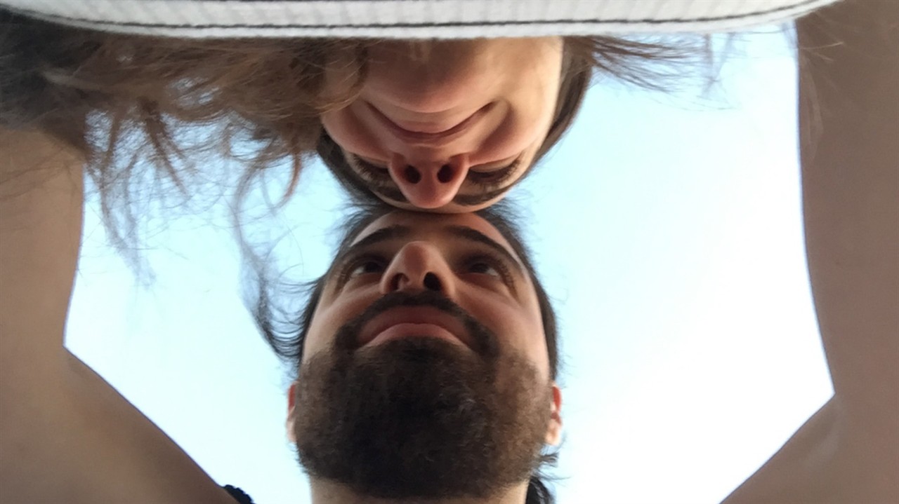 A couple from below, foreheads pressed together